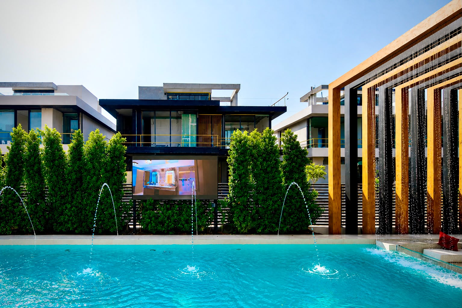 Modern living room with large windows, stylish furniture, and vibrant decor, overlooking a landscaped garden.